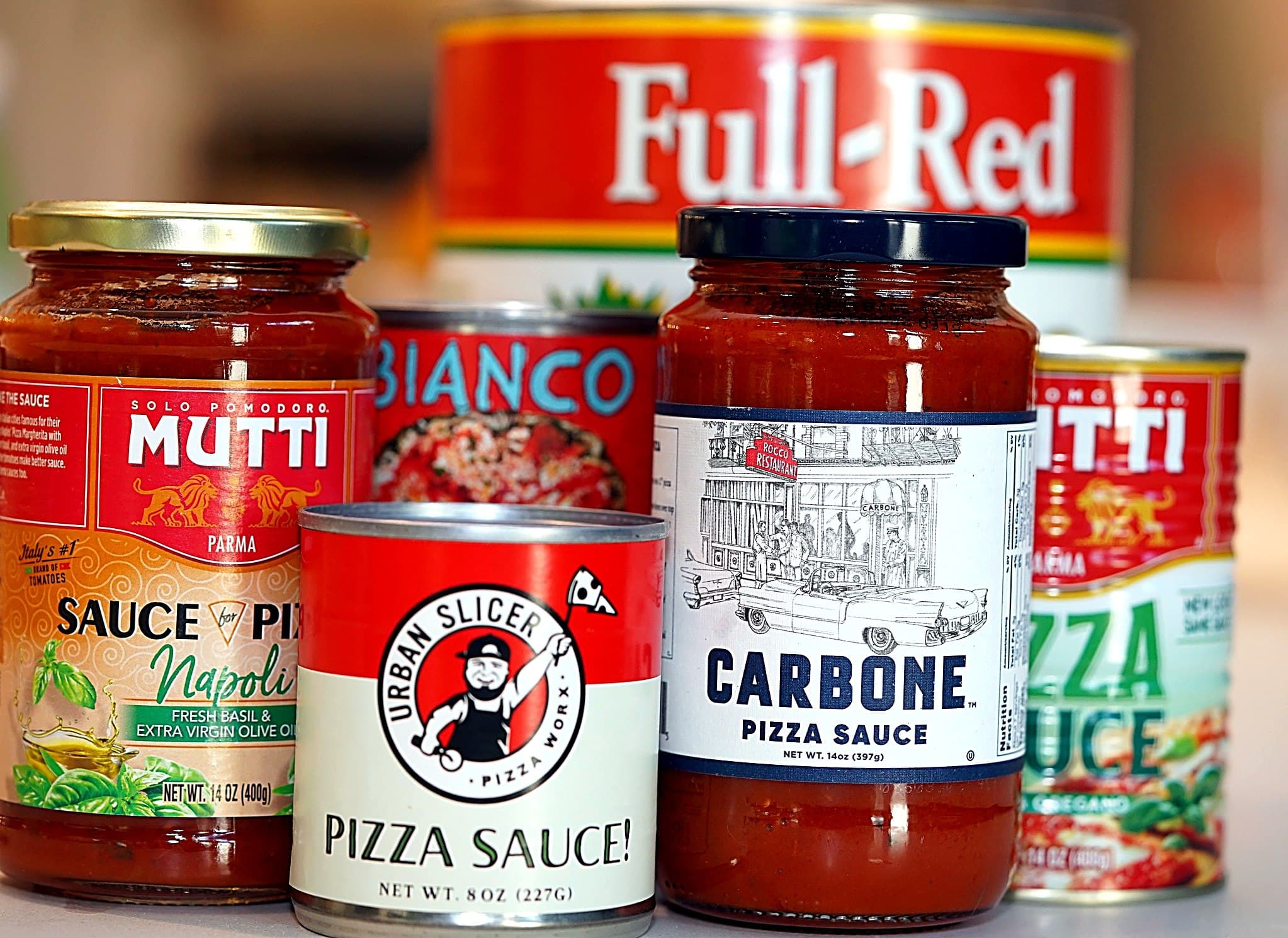 A lineup of pizza and marinara sauces: Mutti, Bianco DiNapoli, Full-Red, Urban Slicer, and Carbone